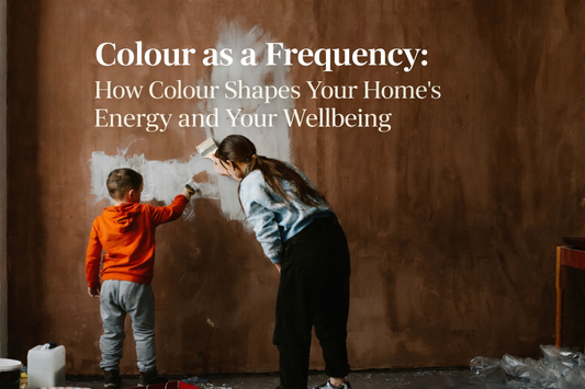 An adult and a young child painting a wall together, covering a dark colour with white paint, symbolising how colour choices in the home can influence energy, mood, and wellbeing